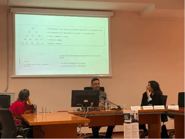 Cristian Montenegro sitting at a desk in front of presentation slides