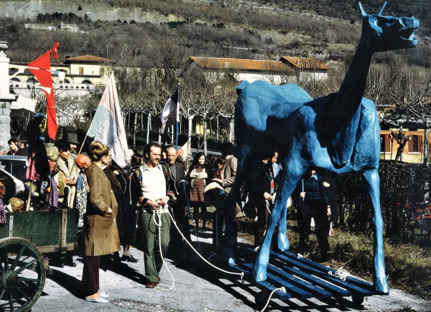 Marco Cavallo, a large blue model horse on wheels and with a small group of people, in Trieste